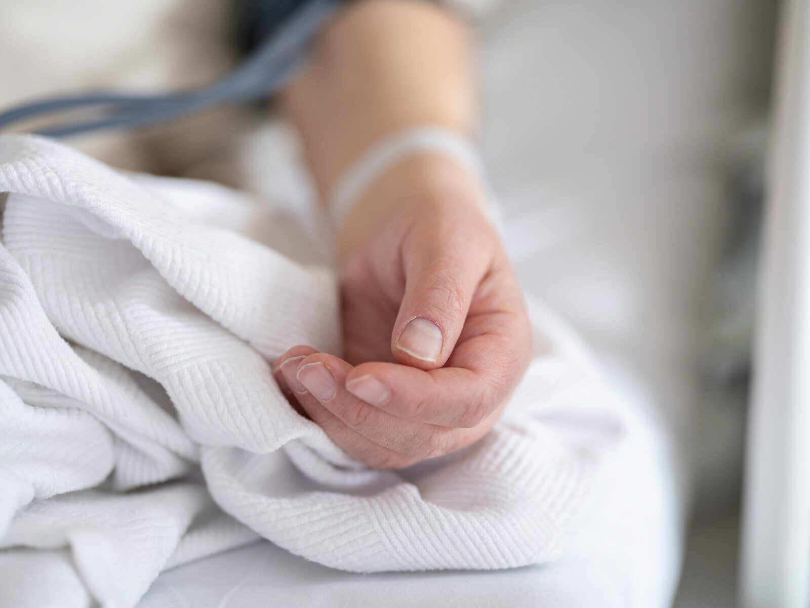 a person with a bandage on their hand sitting on a bed